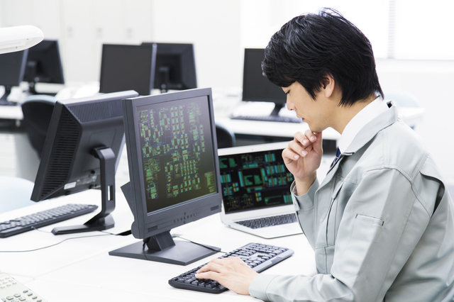 事務所で悩む男性